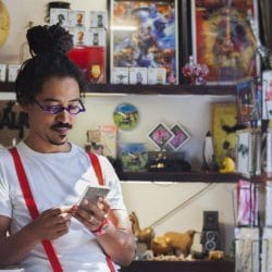 Young professional looks down at his mobile phone while inside a store.