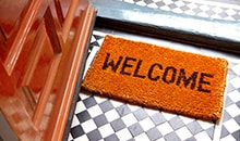 Welcome mat placed at the doorstep of a home where the family used home equity to help pay off their debt.