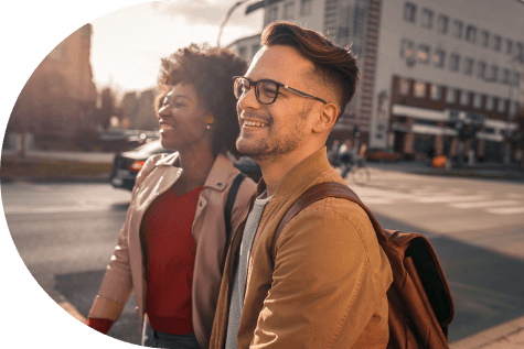 Couple walking in the city, smiling after opening a checking account online.