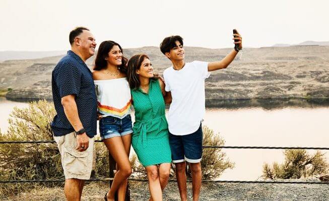 Family posing for picture while on vacation.