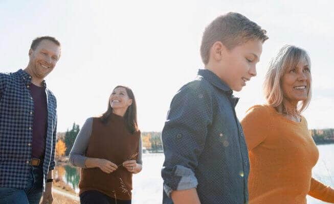 Family enjoys hike near lake.