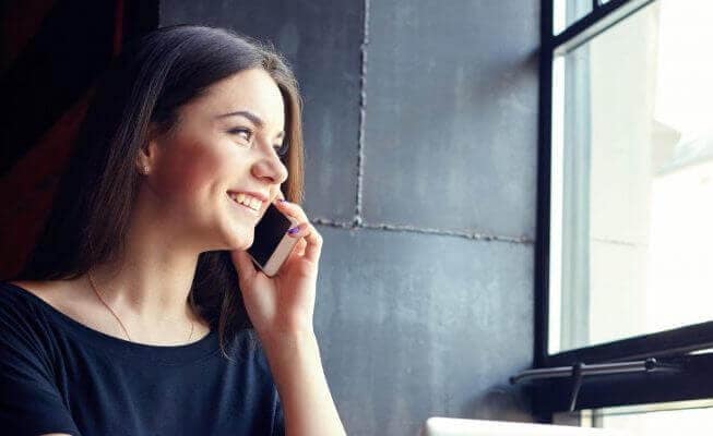 Woman talks on phone after opening a CD account online.