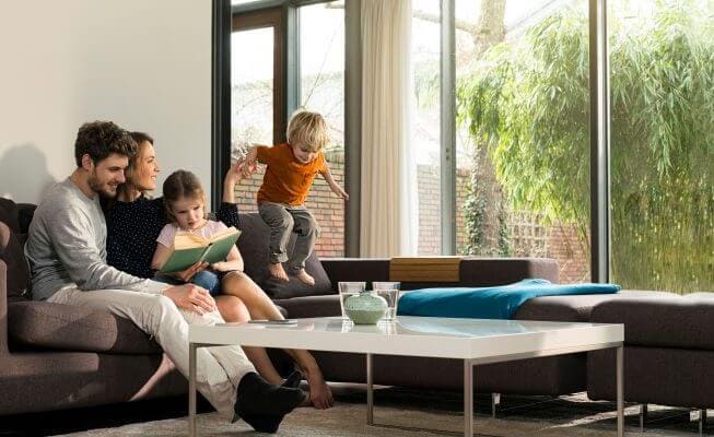 Young family reading a book toghether at home.