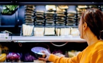Woman shopping for produce at grocery store.