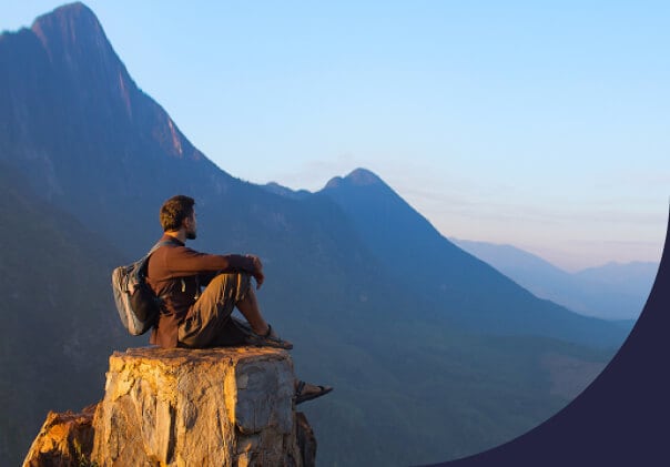 Man hiking stops to look at the mountain view.