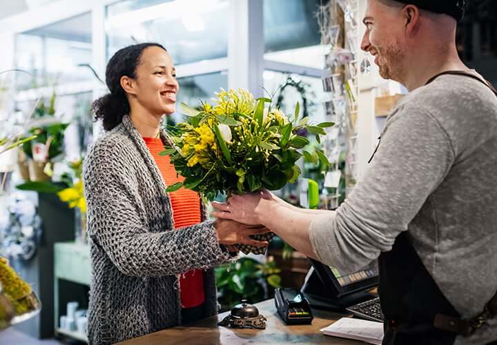 Woman purchasing flowers using Samsung Pay.