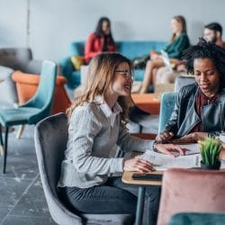 Three women sit at a table in a cafe.