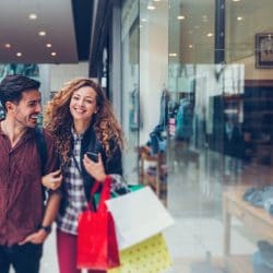 A happy couple shops at the mall.