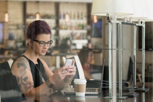 A woman in her office browses her cellphone.