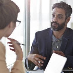Coworkers speak together in an office.