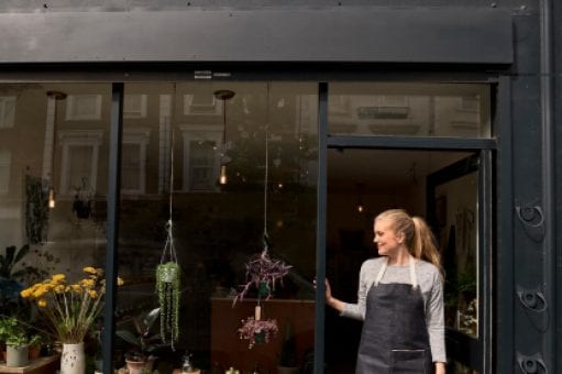 Florist stands in the doorway of her store.