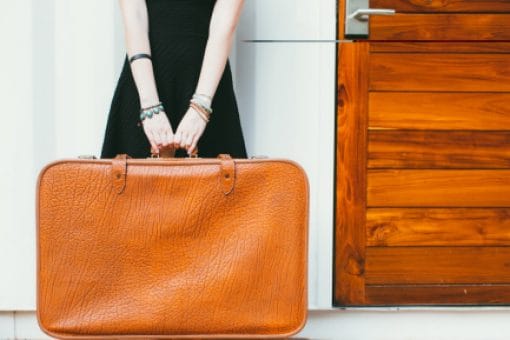 Woman holds leather suitcase