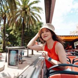 A person explores a new place from atop a double-decker bus.