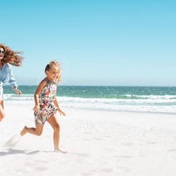 A cheerful family playing at the beach under the bright sun.