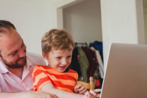 Man pays his credit card bill on a computer with his son.