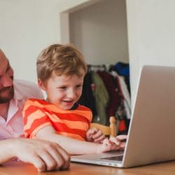 Man pays his credit card bill on a computer with his son.