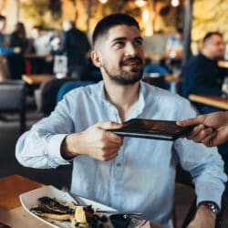 A man is handed the bill at a restaurant.
