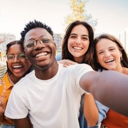 A group of smiling friends take a picture together.