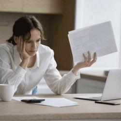 A frustrated woman looks over her credit card statements.