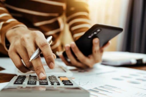 A person creates a budget using a calculator.k