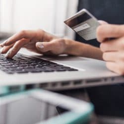 Person enters credit card information on laptop.
