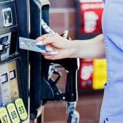 A driver uses their credit card to pay for fuel at the pump.