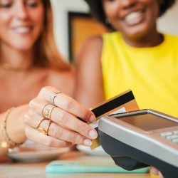 A woman uses her credit card at a point-of-sale terminal.
