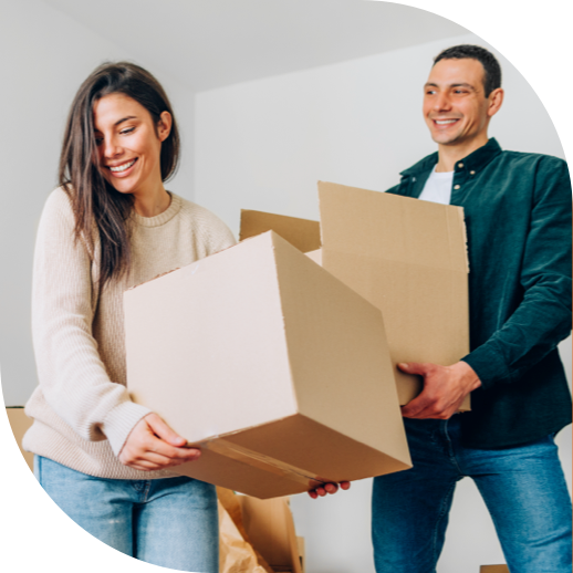 a man and woman smiling and each carrying a cardboard box