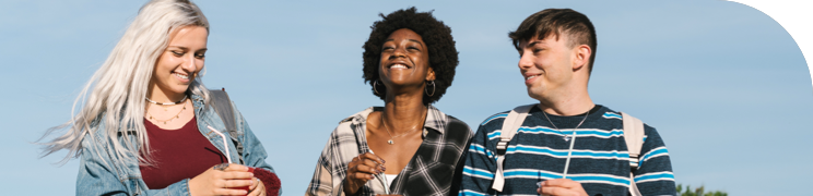 Three friends walking outdoors, smiling and enjoying the day, with a blue sky background.
