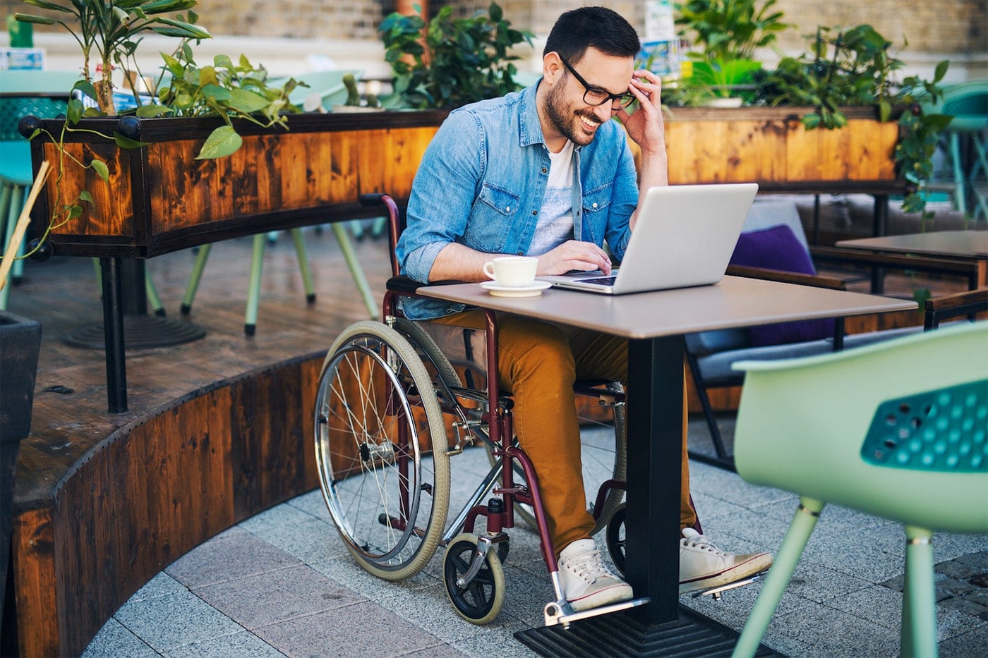 Man in wheelchair using laptop to view Discover No Annual Fee Credit Card advantages