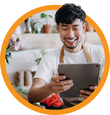 smiling man wearing apron uses mobile tablet