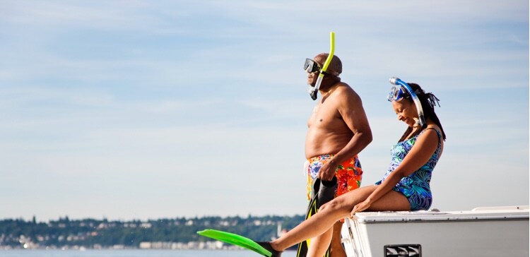 Image of a family sitting on the edge of a boat ready to swim
