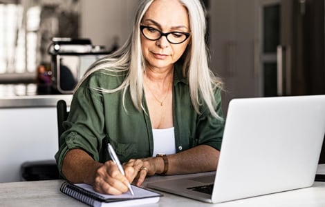 Image of a woman at her computer working on her finances