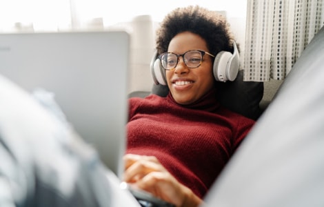 Image of a woman with headphones on her computer