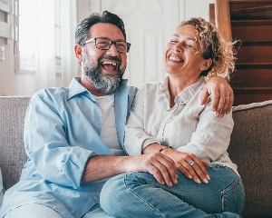 Couple looking at laptop and smiling.