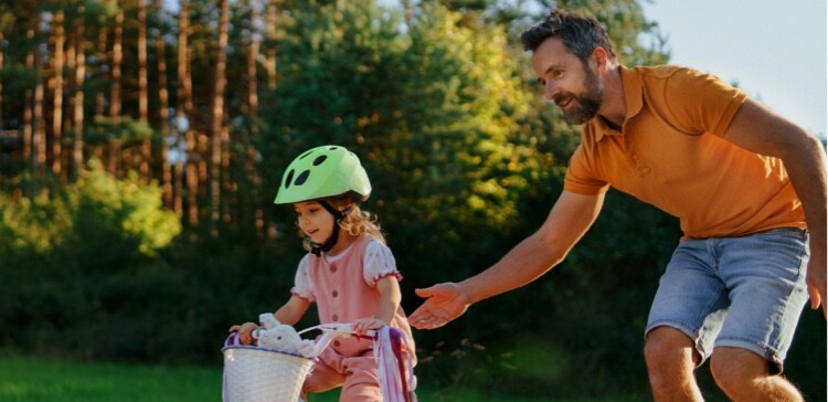 Image of dad helping daughter ride a bike