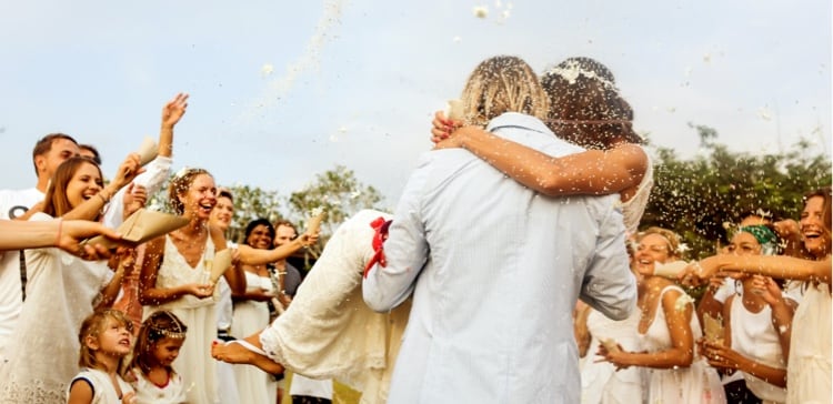 Image of a groom holding and celebrating the bride at a wedding
