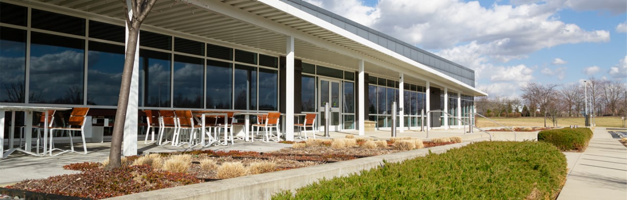 Photo of outdoor dining tables at Discover office with blue sky and clouds in the background.