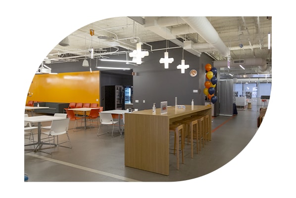 Interior of Discover office building open floor plan workspace, lit by LED pendant lights.