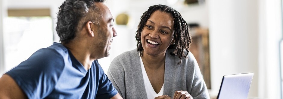 Couple sitting at a table and researching mortgage refinance options