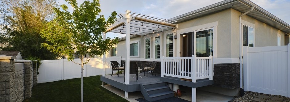 One story home with a front porch and white fencing