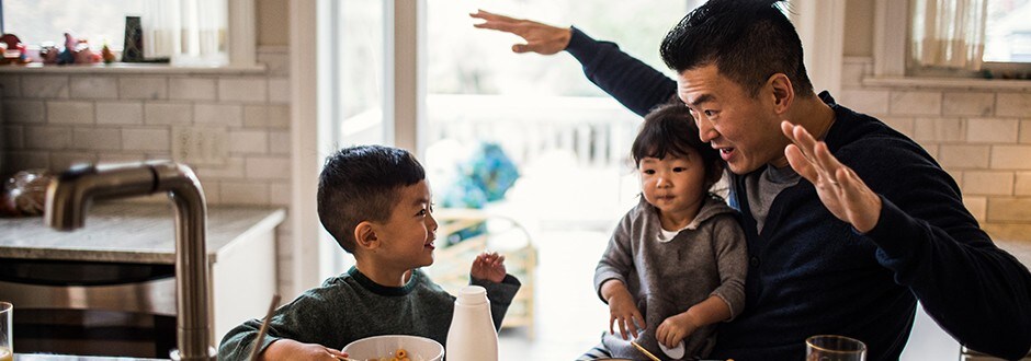 Father and children having breakfast in kitchen of their new house