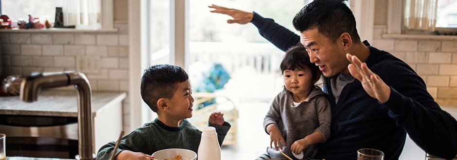 Father acting out the home buying process for his kids in the kitchen of their new house.