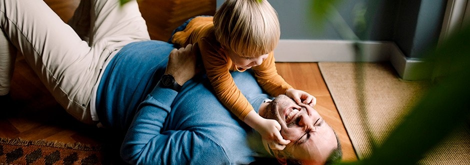 Happy father playing with his son inside the duplex that he bought to live in and rent out