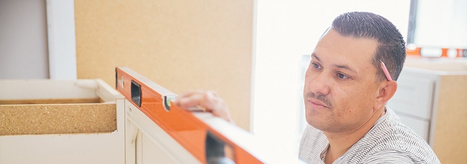Great home contractor measuring a kitchen cabinet as part of a home remodel project