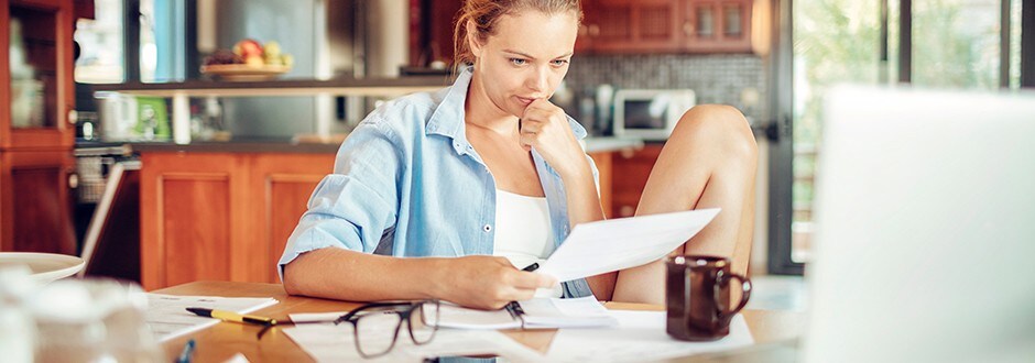 Young woman looking at her longstanding debt considering the best way to consolidate it.