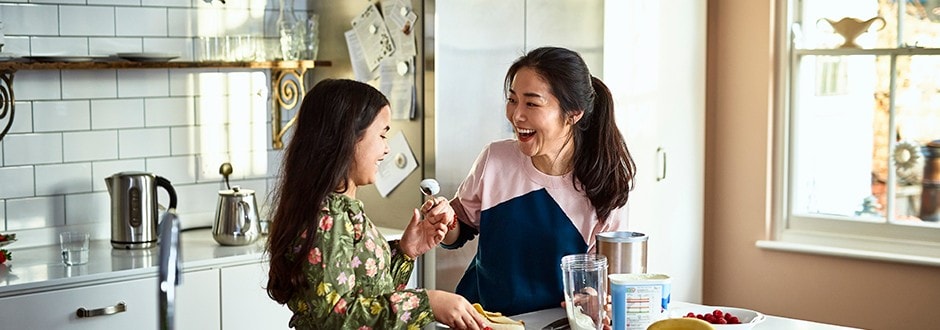 Mother and daughter laughing in the kitchen that they remodeled with funds from refinancing their home