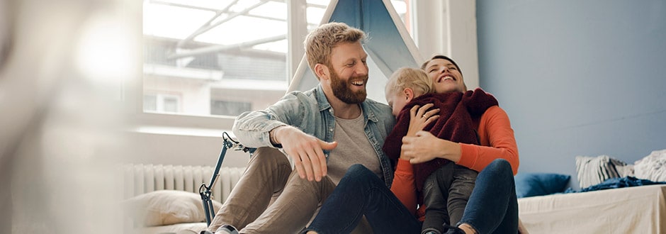 Family giving their child a hug in their living room after closing a mortgage refinance