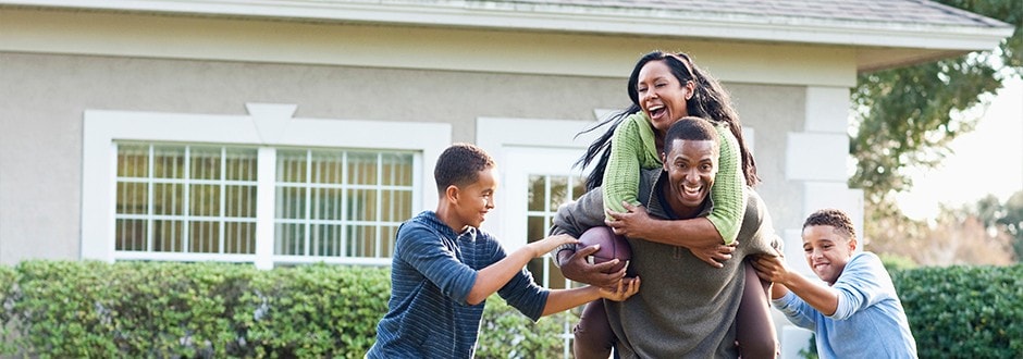 Family playing sports in yard while waiting for their true market value home appraisal