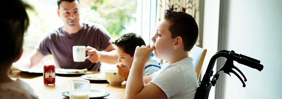 Family eating breakfast at the kitchen table in their wheelchair accessible home